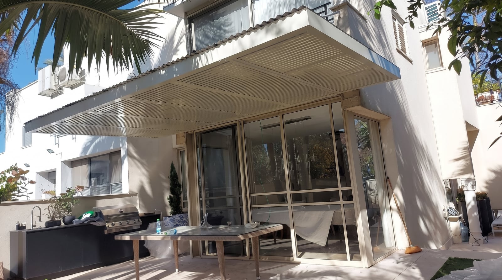 פרגולת הייטק שדות בגוון קרם מעל פטיו ומטבח חוץ צמוד לבית